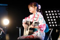 アコースティックギターで弾き語りする鈴木萌花。（写真提供：スターダストプロモーション）