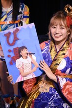 前髪を切り過ぎてしまった頃の自分のパネルを持つ星名美怜。