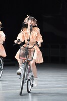 自転車に乗って「初恋サイクリング」を歌う坂井仁香。