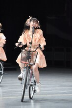 自転車に乗って「初恋サイクリング」を歌う坂井仁香。