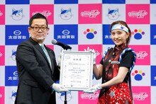 株式会社太田胃散の太田淳之代表取締役副社長（左）から太田胃にゃん応援隊の任命書を受け取る百田夏菜子（右）。（写真提供：太田胃散 PR事務局）