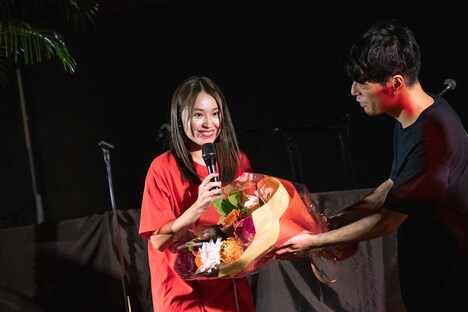 脇田もなり（左）に4周年を祝う花束を贈呈するDorian（右）。