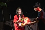 脇田もなり(左)に4周年を祝う花束を贈呈するDorian(右)。