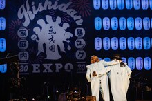 「アバンギャルド」を歌い終え、仲良く肩を組んで去るカールスモーキー石井（左）とジェームス小野田（右 / 米米CLUB）。（撮影：上山陽介）