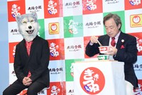 武田鉄矢（右）の試食を見守るJean-Ken Johnny（左 / MAN WITH A MISSION）。