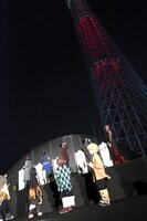 炎色にライトアップされたスカイツリーを見上げる登壇者たち。