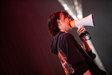 拡声器を手に歌う安本彩花。