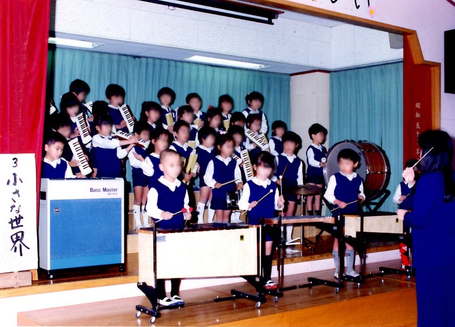 幼稚園で鍵盤を弾く蓮沼(左端)。