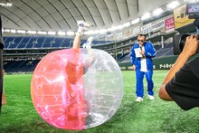 逆立ち状態のカエデフェニックスとそれを見つめるたむらけんじ。