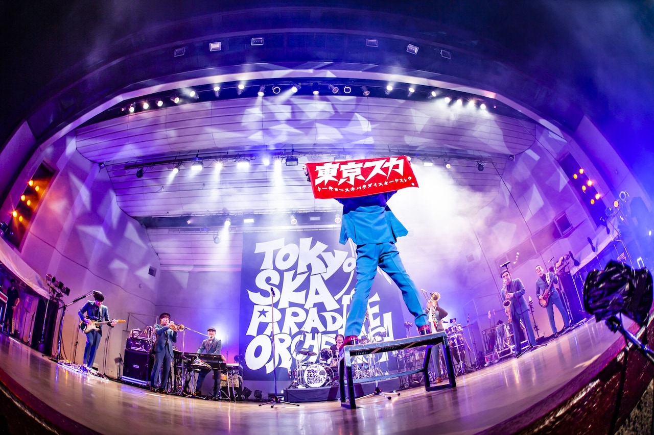 東京スカ」のタオルを掲げる谷中敦（Baritone Sax）。（撮影：青木