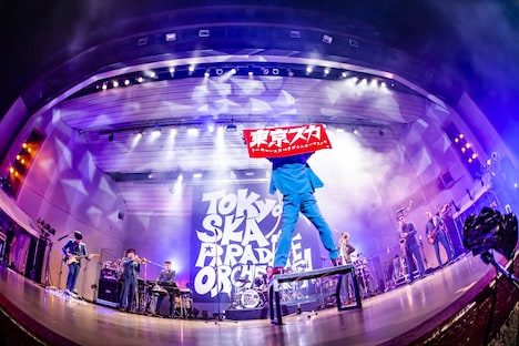 「東京スカ」のタオルを掲げる谷中敦(Baritone Sax)。(撮影:青木カズロー)