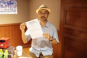 「リアル通信ゲーム」の企画書を持つ加藤さん。