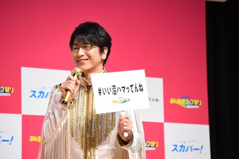 「いい沼ハマってんね」の札を掲げる及川光博。