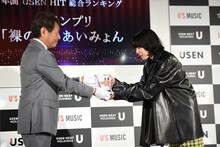 USEN-NEXT HOLDINGS代表取締役社長CEO宇野康秀氏から盾を受け取るあいみょん（右）。