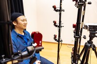 顔にたくさんのマーカーを貼り、その動きを特殊なカメラで記録しています。