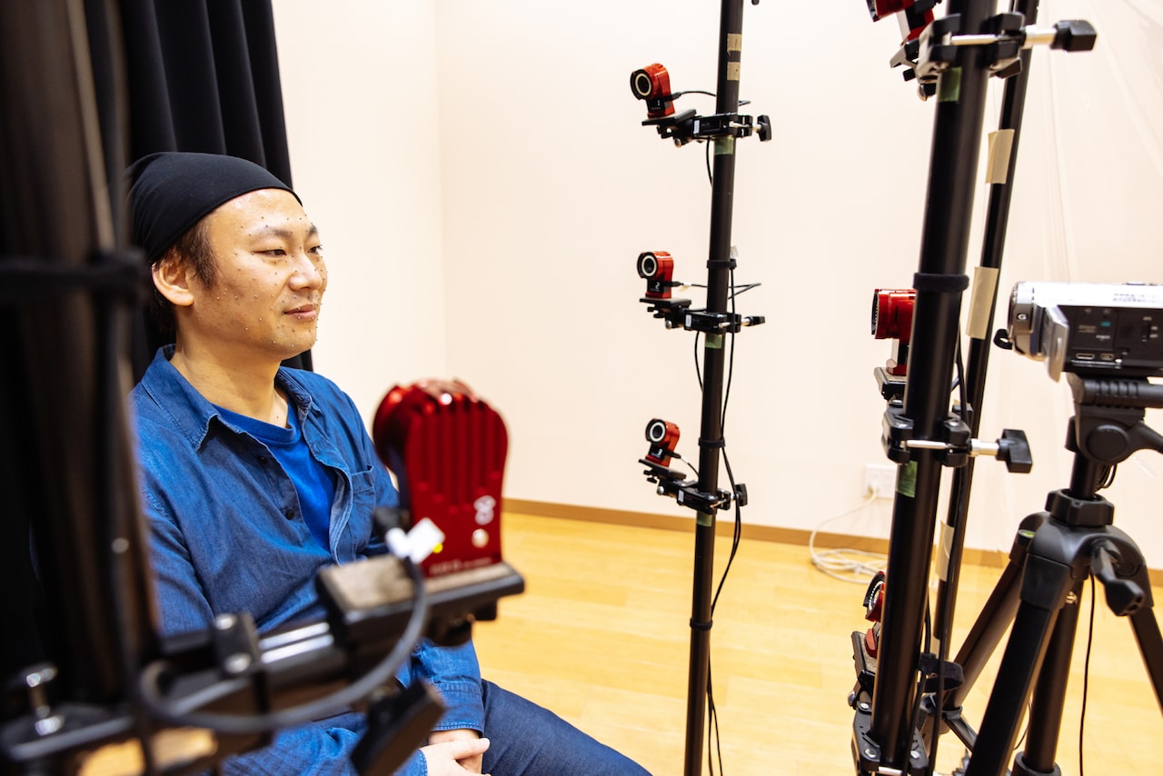 顔にたくさんのマーカーを貼り、その動きを特殊なカメラで記録しています。