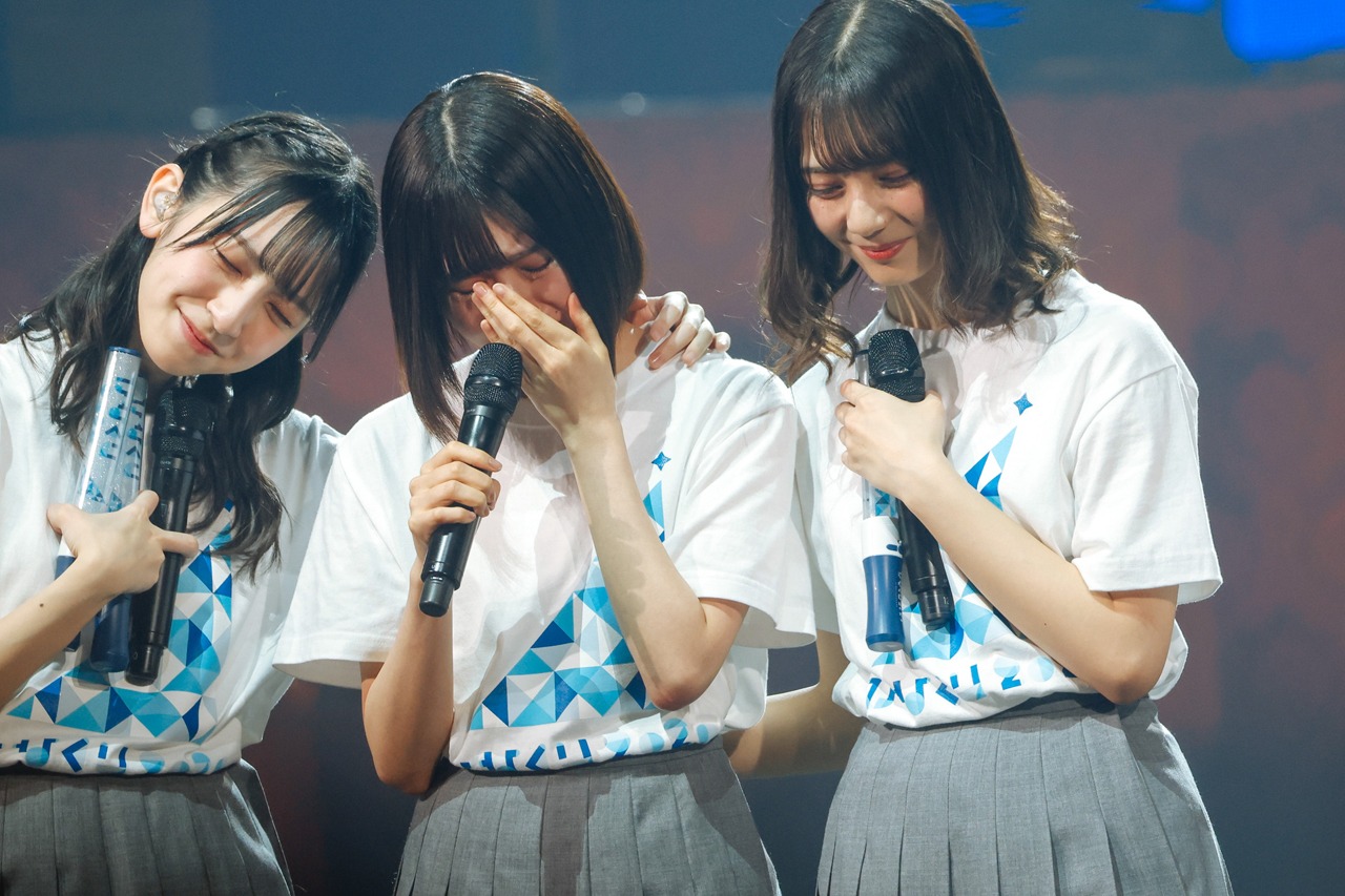 泣き出す松田好花（中央）に寄り添う金村美玖（左）と小坂菜緒（右）。(c) Seed & Flower LLC