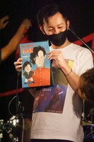 スローセックス石島（Dr）。手にしているのは益子寺かおり（Vo）が描き下ろしたイラスト。（Photo by N.ARAKI）