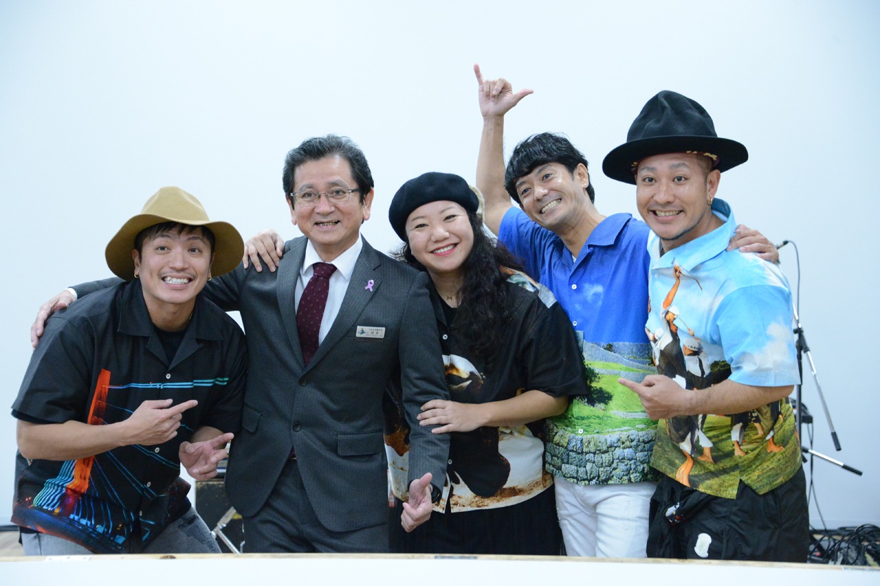 うるま市の上間秀二副市長と肩を組むHYのメンバー。