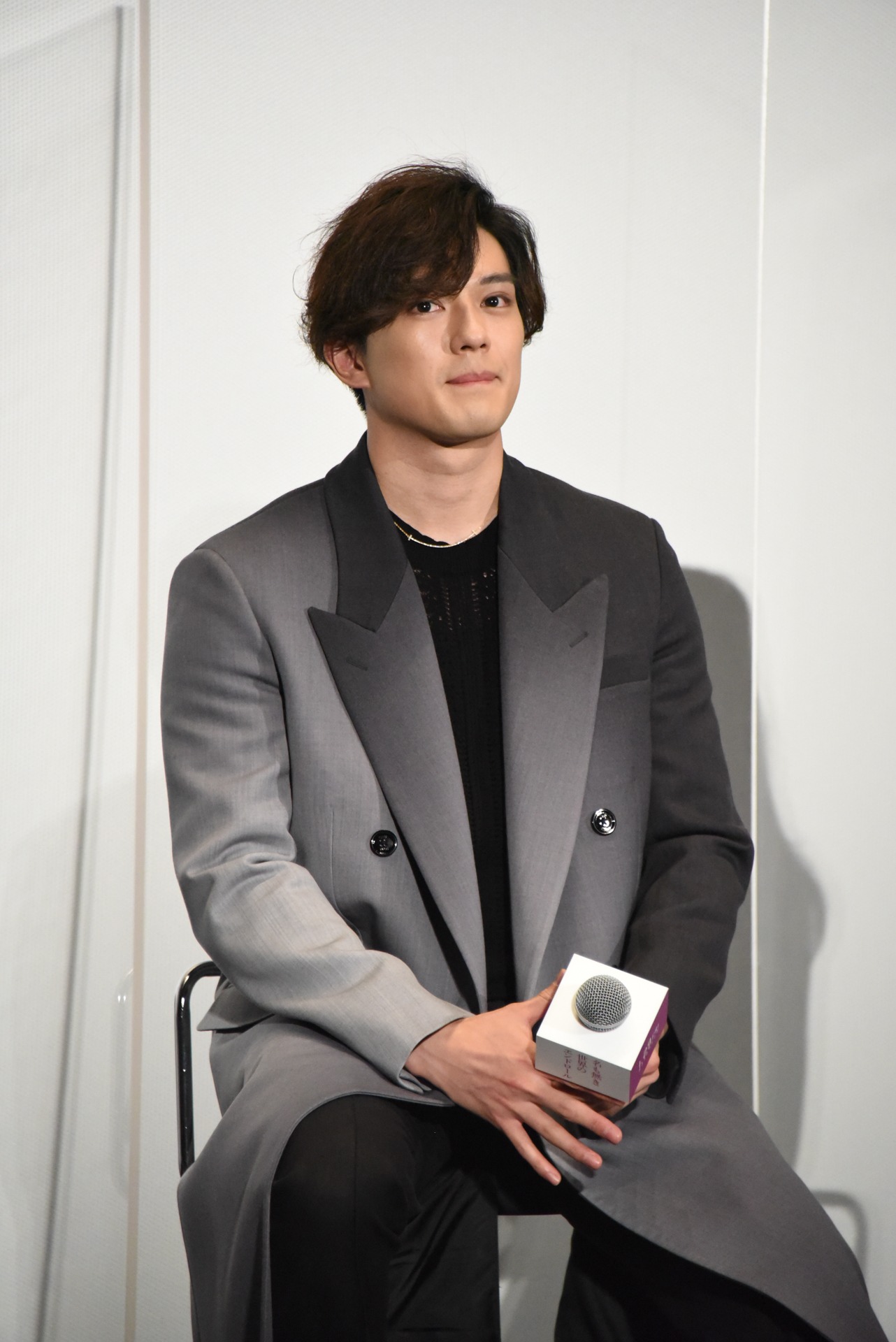 話を聞く新田真剣佑。