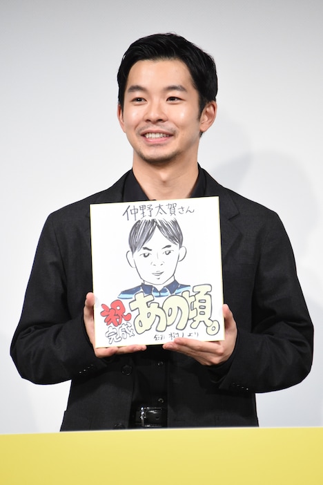 劔樹人による似顔絵を手にする仲野太賀。