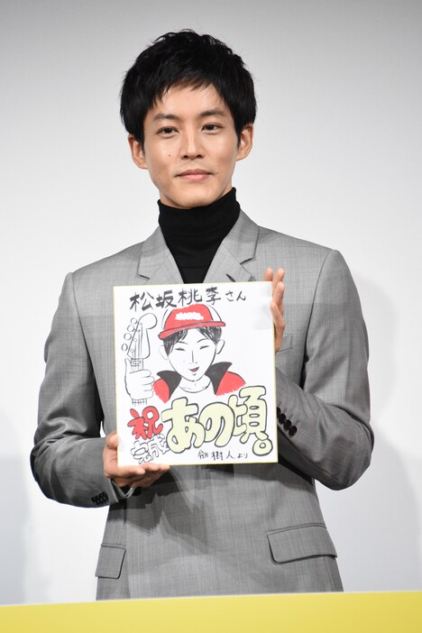 劔樹人による似顔絵を手にする松坂桃李。