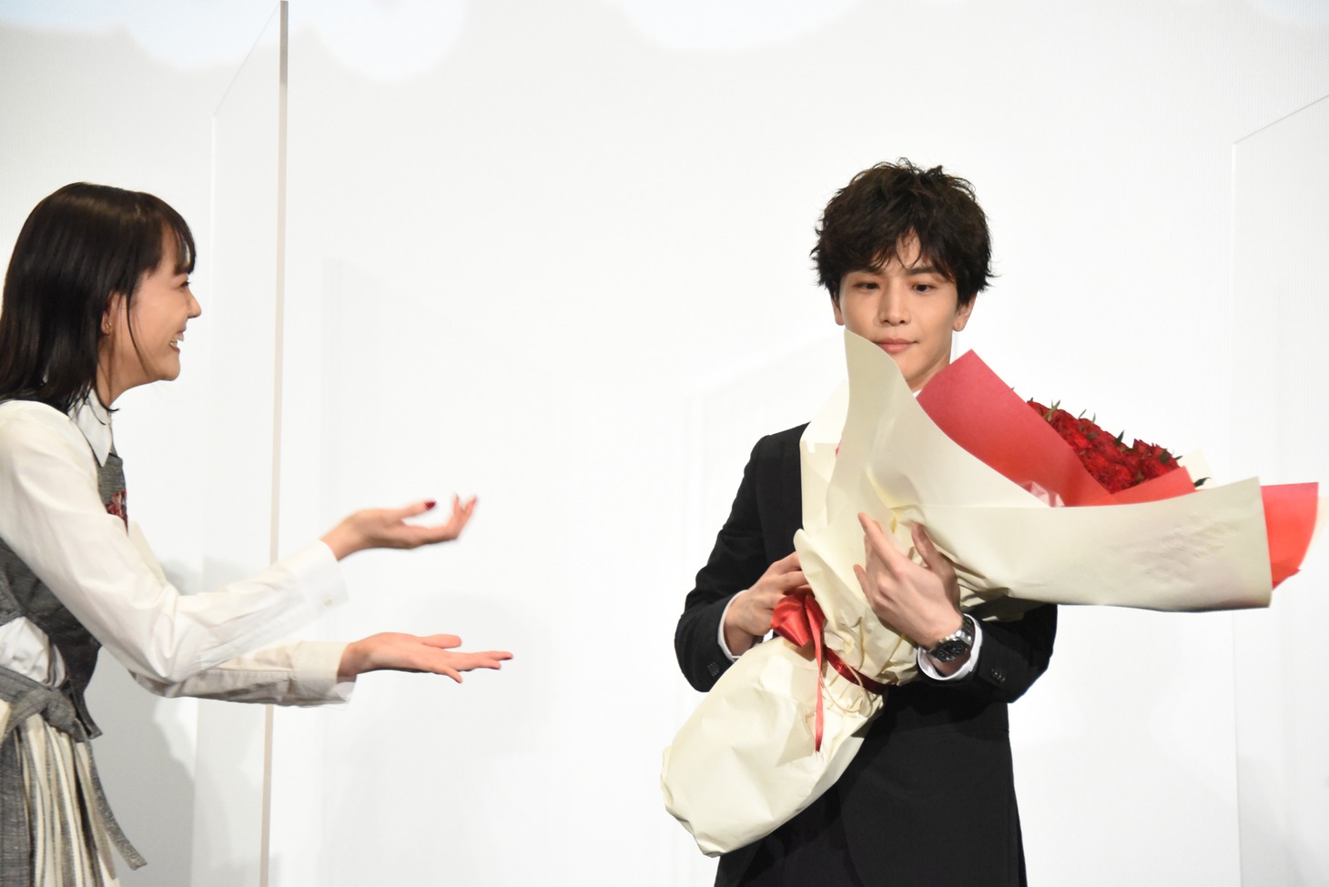 松井愛莉（左）からバラの花束を受け取った岩田剛典（右）。
