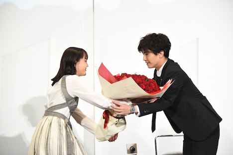 松井愛莉（左）から花束を受け取る岩田剛典（右）。