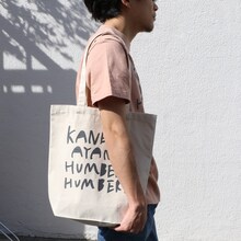 「ライブナタリー “カネコアヤノ×ハンバート ハンバート”」Tシャツとトートバッグの着用イメージ。