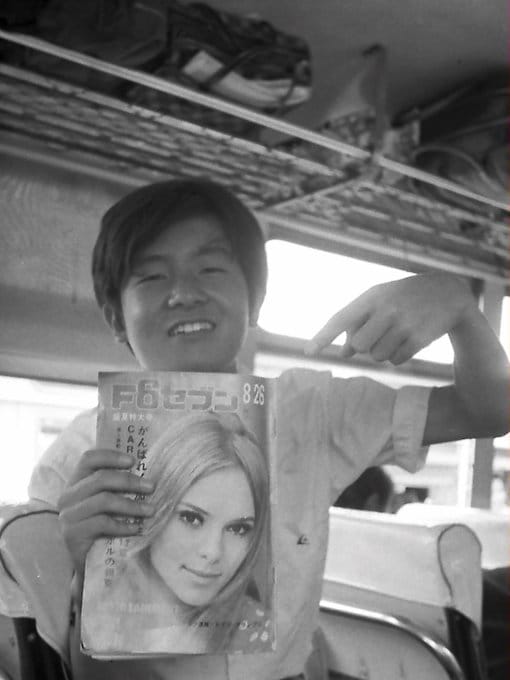 ワンダーフォーゲル部の合宿のため移動中のバスの中で。「週刊F6セブン」を持つ高校時代の鈴木慶一。