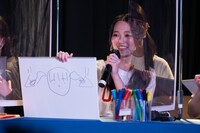 ツインテールがつり革に引っかかった絵を見せる青春高校3年C組の前川歌音。