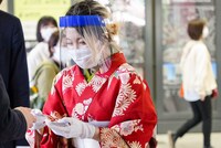 名刺を配る藤原ここ。