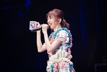 生誕グッズのマグカップを紹介する真山りか。