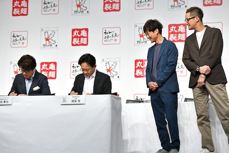 調印調書に署名する城島茂（左から2番目）とそれを見守る国分太一、松岡昌宏。