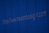 Maison book girlのオフィシャルサイトのURLが投影されたスクリーン。（撮影：稲垣謙一）