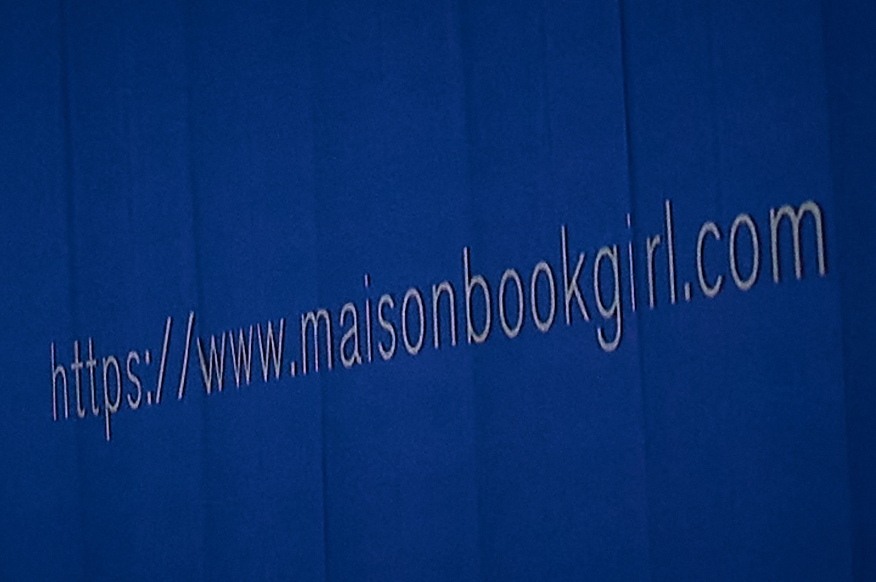 Maison book girlのオフィシャルサイトのURLが投影されたスクリーン。（撮影：稲垣謙一）
