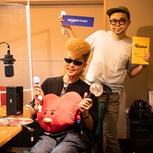 左からTATAのクッションを抱き、アミボムを持った綾小路翔、西寺郷太。