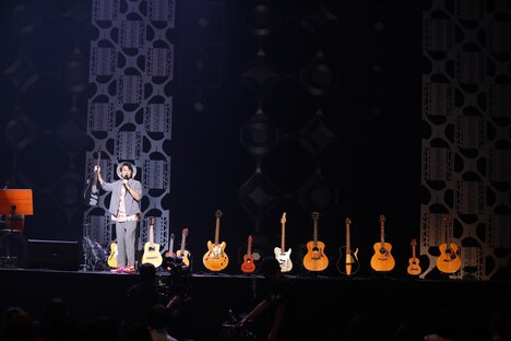 ステージ後方に並べられたギターを紹介するナオト・インティライミ。(写真提供:株式会社 エンジン)