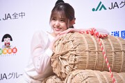 米俵を抱く松村沙友理。