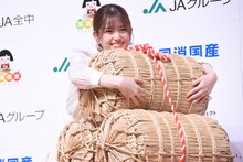 米俵を抱く松村沙友理。