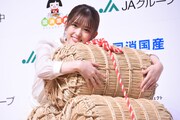 米俵を抱く松村沙友理。