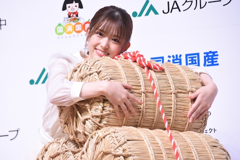 米俵を抱く松村沙友理。