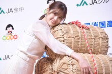 米俵を抱く松村沙友理。