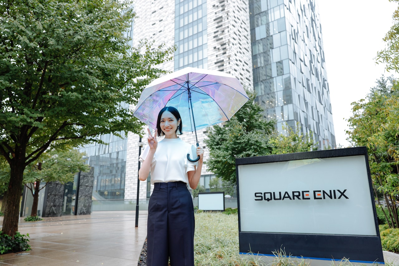 スクウェア・エニックス本社に到着し、ピースをするのっちさん。