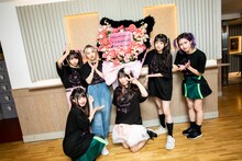 ファンから送られたスタンド花を囲むMIGMA SHELTER。（Photo by Masayo）