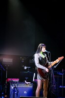 ギターを弾きながら歌うminan。