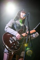 ギターを弾きながら歌うminan。