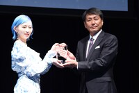 USEN-NEXT HOLDINGS代表取締役社長CEO・宇野康秀氏よりトロフィーを受け取るPORIN（Awesome City Club）。