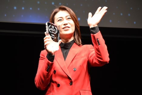 トロフィーを持ちながら手を振る氷川きよし。