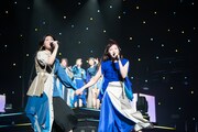 手をつないでステージを歩く小林歌穂（左）と中山莉子（右）。